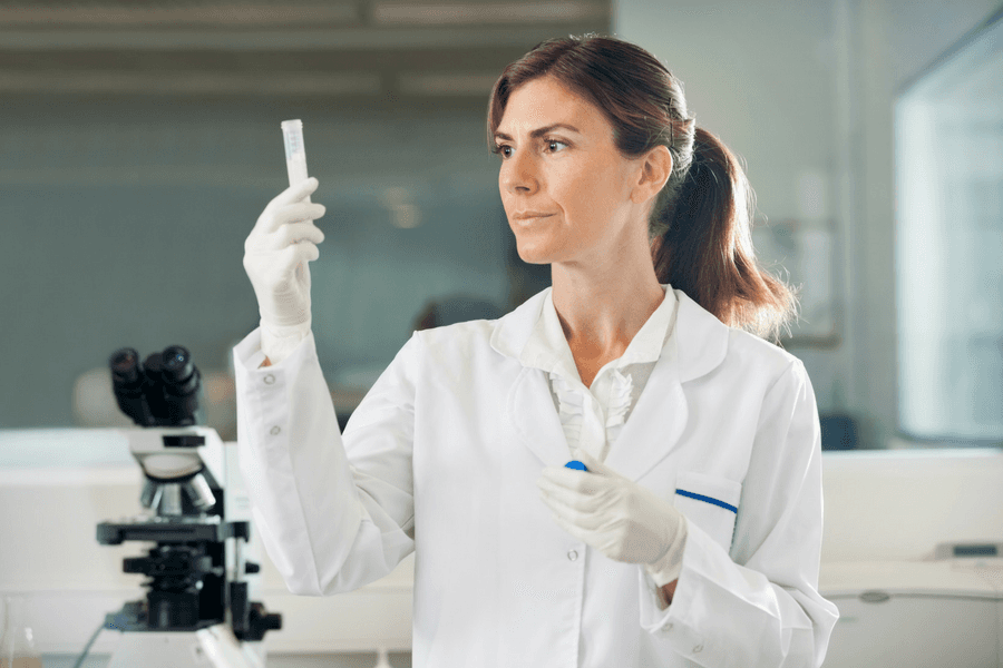 A female scientist is looking at a test tube in a laboratory.